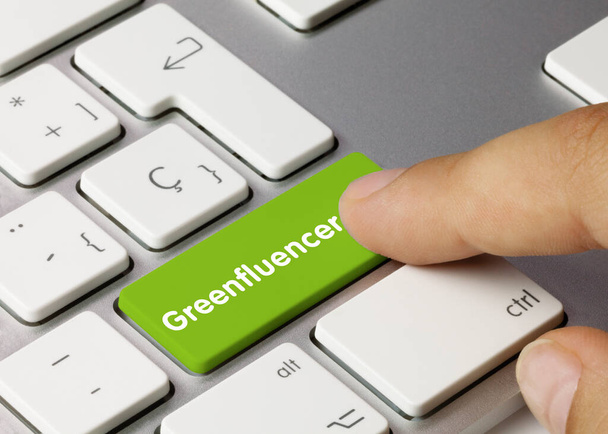 Greenfluencer napisany na zielonym klawiszu klawiatury metalowej. Naciśnięcie klawisza palca. - Zdjęcie, obraz