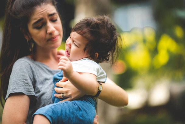 mother calms crying baby boy outside - Photo, Image