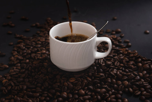 Verter un poco de café en una taza aislada en la vista lateral del fondo del café - Foto, imagen