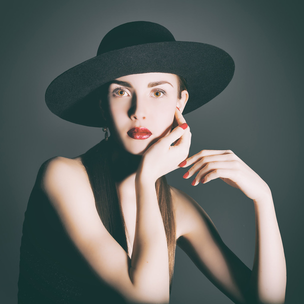 Portrait of young woman in a black hat. - 写真・画像