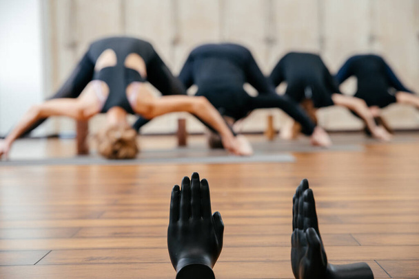 Yoga pratiği yapan bir grup kadın tahta bloklar kullanarak, omurga ve omuz esnekliği için egzersiz yapıyorlar. - Fotoğraf, Görsel