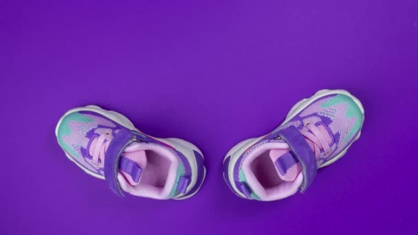 Multicolored Girls sneakers with mershmello on purple background stop motion - Footage, Video