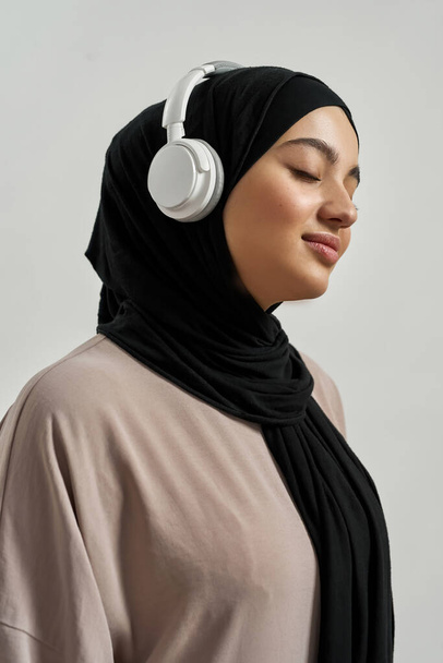 Portrait of happy young arabian girl in headphones sideways - Photo, Image