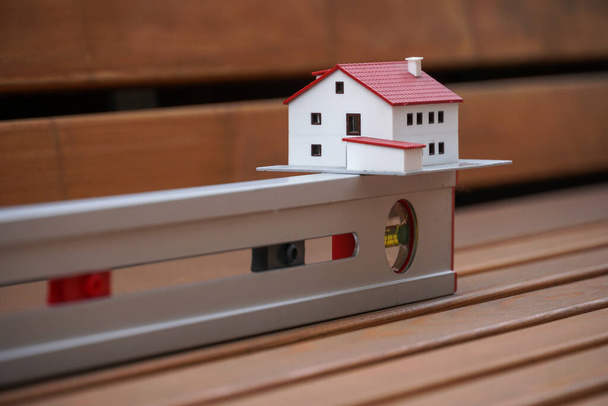 Концепция недвижимости. Модель дома и уровень трубного духа, символы новых строительных проектов - Фото, изображение