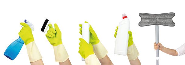 Vue du dessus de la main en gants de caoutchouc jaune retenant la collection de fournitures de nettoyage isolée sur fond blanc. Concept de nettoyage de printemps. - Photo, image