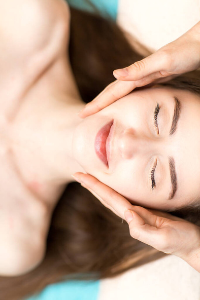 Young beautiful woman receiving head face massage in beauty spa - Fotografie, Obrázek