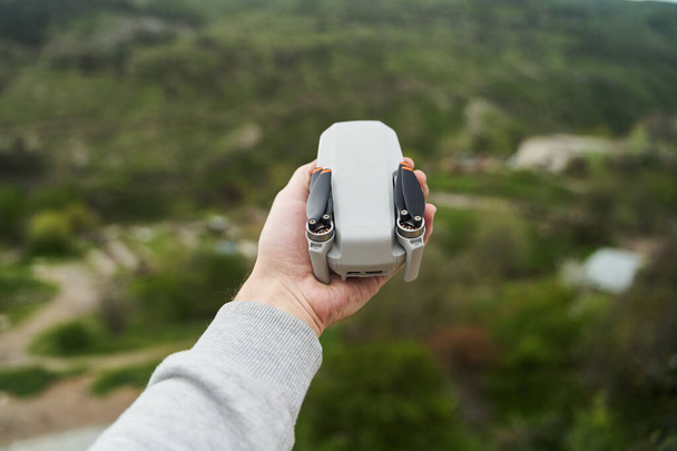 Moderno pequeño quadcopter compacto en la mano de un hombre. Lanzando un dron desde tu mano. Foto de alta calidad - Foto, Imagen