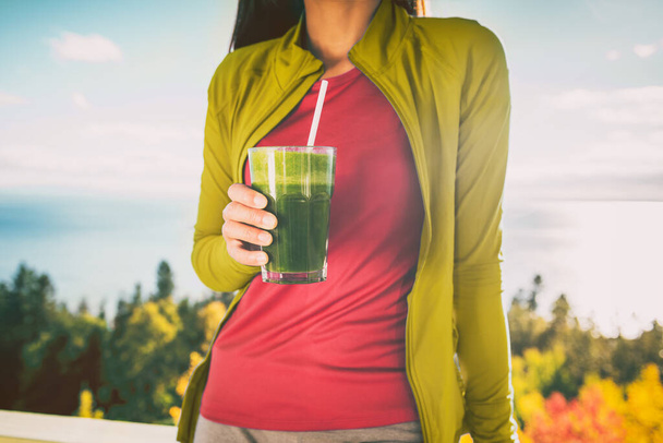 Green smoothie breakfast detox diet food cleanse juice drink. Woman eating healthy for weight loss, morning meal outside in autumn nature - Foto, afbeelding