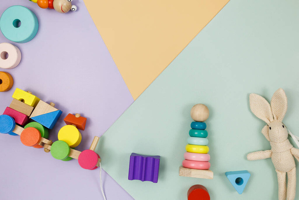 Gruppo di giocattoli in legno multicolore su sfondo viola, verde, beige. Giochi prescolastici o diurni, istruzione - Foto, immagini