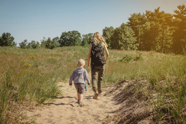 Moeder en jonge zoon wandelen langs een pad in Indiana Dunes State Park. - Foto, afbeelding