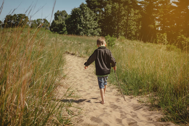 Niño caminando con los pies desnudos en un sendero en Indiana Dunes State Park. - Foto, imagen