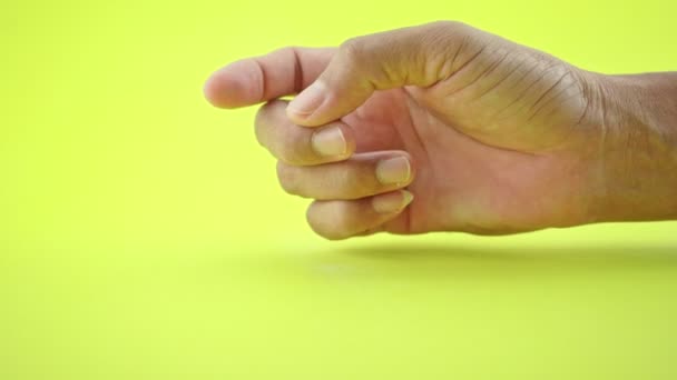 Ręczny gest człowieka znak oczekiwania i umieszczenie palca stół i palce Czeka lub myśli coś izolowane na żółtym tle - Materiał filmowy, wideo