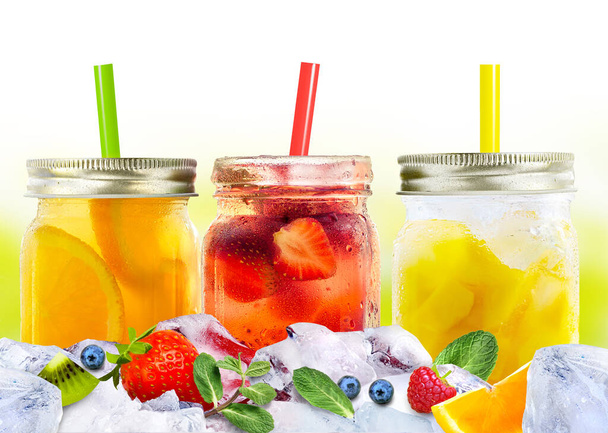 Яркие красочные освежающие летние напитки в стеклянных банках и соломинках на льду с фруктами и ягодами - Фото, изображение