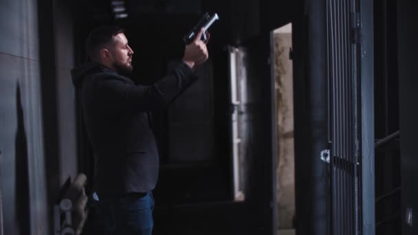 Erwachsener Mann steckt Waffe hinter dem Rücken in die Hose - Filmmaterial, Video