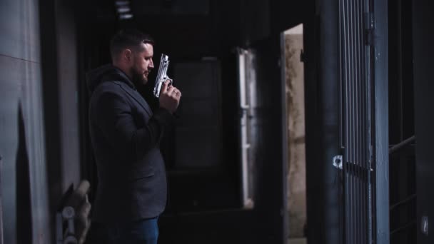 Erwachsener Mann hält zwei Gewehre in den Händen und schaut über sie hinweg - Filmmaterial, Video