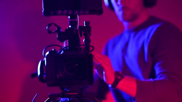 Operador de cámara caucásico probando nuevo equipo de video dentro del estudio - Imágenes, Vídeo