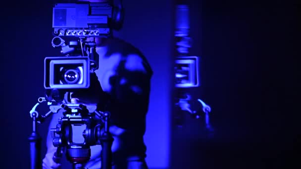 Mannen nemen van video schot in blauw verlichte kamer - Video
