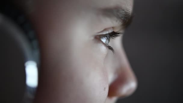 blank meisje met koptelefoon in de voorkant van computer display close-up - Video