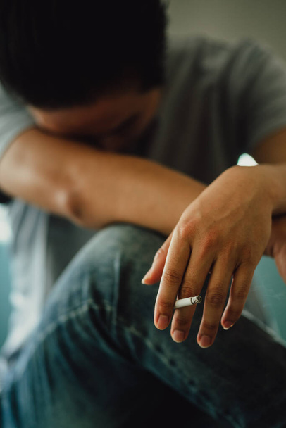 Ασιάτης άνθρωπος αισθάνεται απελπισμένος για εθισμό στο κάπνισμα - Φωτογραφία, εικόνα