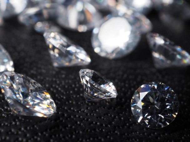 Крупный план блестящих бриллиантов. Съемка на черном текстурированном фоне - Фото, изображение