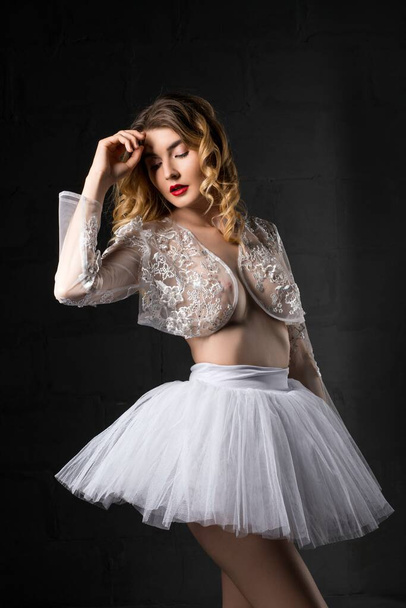 Seductive ballerina in white clothes touching head - Foto, imagen
