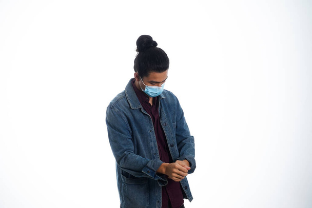 health, pandemic and safety concept - asian young man wearing face protective medical mask for protection from virus disease over white background - Foto, Imagem