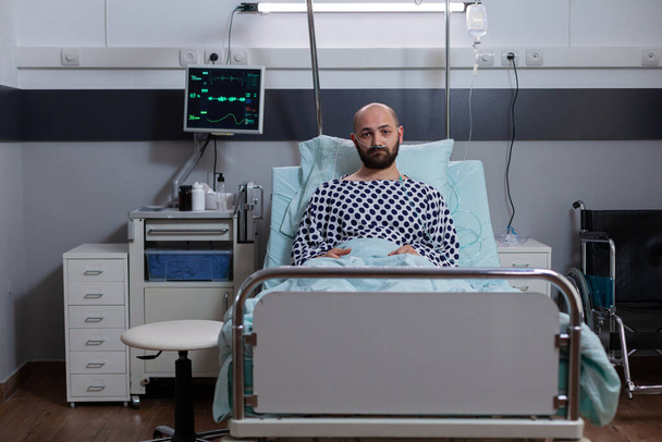 Potrait of depressed sick man lying in bed waiting for respiratory treatment - Photo, Image