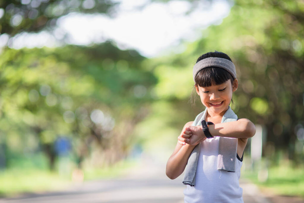happy child girl running in the park in summer in nature. warm sunlight flare. asian little is running in a park. outdoor sports and fitness, exercise and competition learning for kid development. - 写真・画像