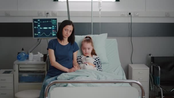 Πορτρέτο της ανήσυχης μητέρας και του παιδιού κορίτσι ψάχνει σε κάμερα durinh εξέταση θεραπεία ασθένεια - Πλάνα, βίντεο