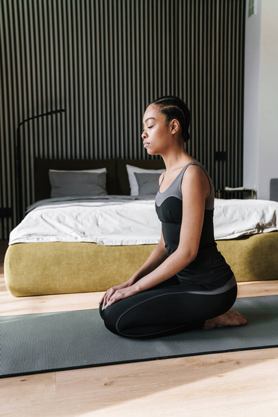 Calm african american girl meditating while doing yoga practice at home room - Fotografie, Obrázek