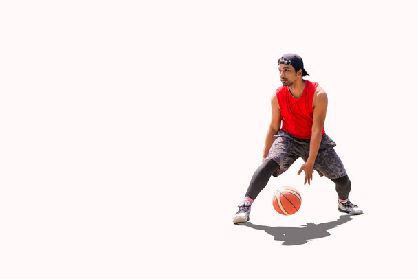 Азиатский баскетболист практикующий дриблинг на цветном фоне с вырезанием пахты - Фото, изображение