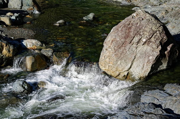 The river flows around a large boulder - Valokuva, kuva