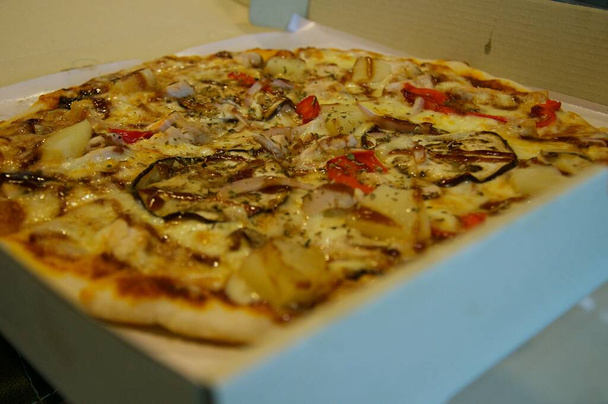 Zbliżenie pizzy z różnymi dodatkami i serem w tekturze wyjąć pudełka z otwartą pokrywą - Zdjęcie, obraz