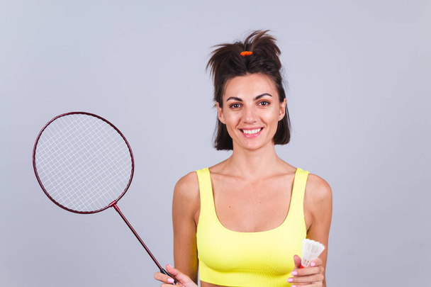 Fit femme en haut de vêtements de sport et leggings tenir raquette de badminton heureux positif gai - Photo, image
