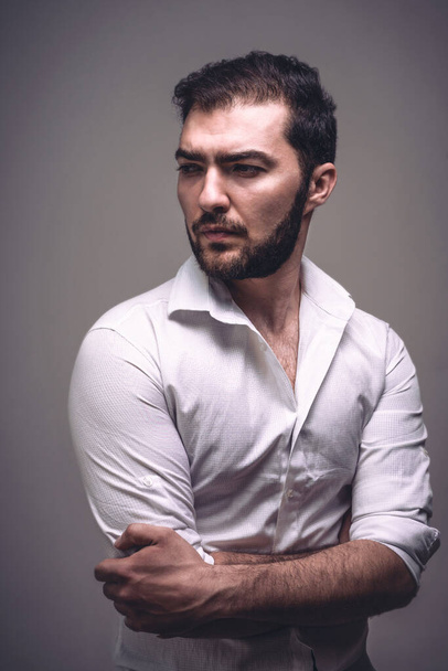 Handsome serious man. Portrait of confident guy with beard in shirt in studio - Zdjęcie, obraz