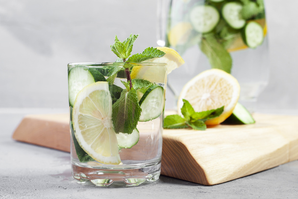 Fresh cool detox water drink with cucumber and lemon. glass of Lemonade with basil and mint leaves. Concept of proper nutrition and healthy eating. Fitness diet. Copy space for tex - Photo, image