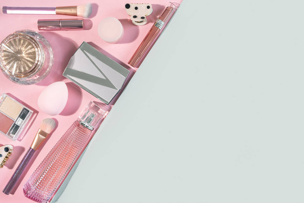 Beauty plat lag met cosmetische mode make-up accessoires op roze en grijze achtergrond. Bovenaanzicht, flat lay, kopieerruimte - Foto, afbeelding