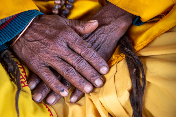 Κοντινό πλάνο από τα σταυρωμένα ρυτιδιασμένα χέρια μιας ηλικιωμένης γιαγιάς νεπαλέζας.. - Φωτογραφία, εικόνα