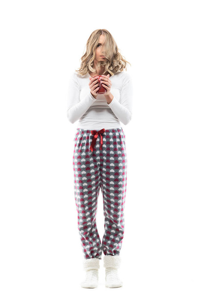 Just woken up woman in pajamas with messed tousled hair holding cup of coffee.  Full body length isolated on white background. - Photo, Image
