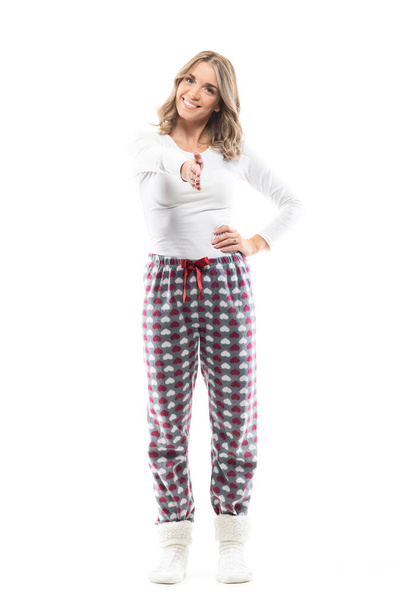 Friendly happy young woman in cozy pajamas offering hand for handshake at camera. Full body length isolated on white background. - Photo, Image