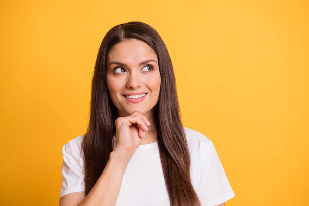 Photo portrait of thoughtful dreamy woman smiling touching chin in white clothes got idea isolated on bright yellow color background - Valokuva, kuva