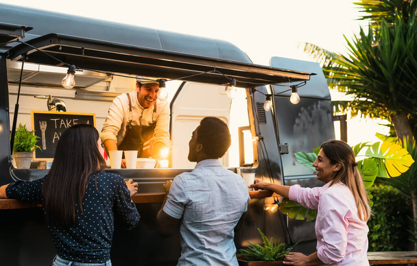 Young people buying meal from street food truck - Modern business and take away concept - Photo, Image