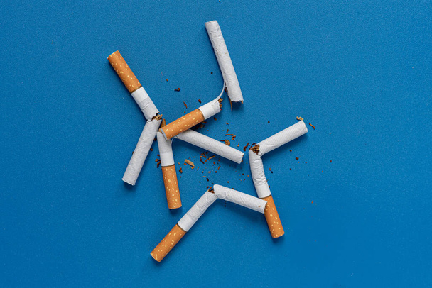 no hay día de tabaco, un cigarrillo roto en el fondo de color aislado en la superficie de color, dejar de fumar - Foto, Imagen
