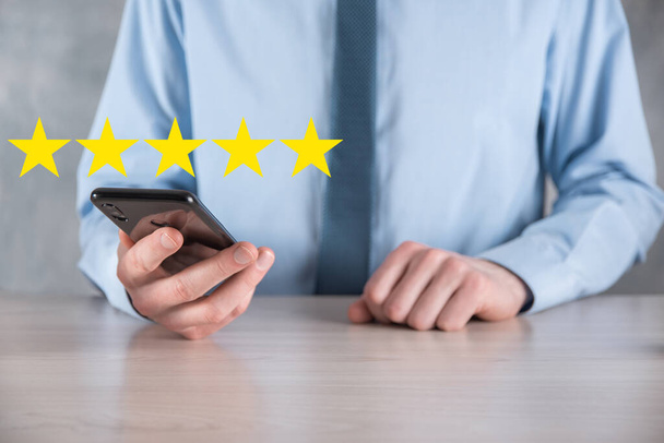 Man käsi älypuhelin osoittaa viiden tähden erinomainen rating.pointing viiden tähden symboli lisätä luokitus company.Review, lisätä luokitus tai ranking, arviointi ja luokittelu käsite - Valokuva, kuva