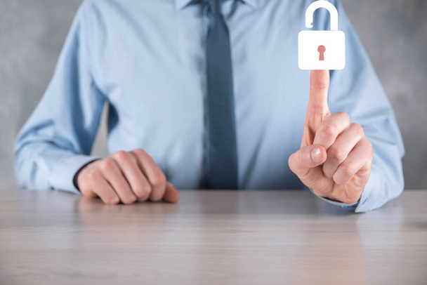 Businessman holds an open padlock icon on his palm.unlocking a virtual lock. Business concept and technology metaphor for cyber attack, computer crime, information security and data encryption - Photo, Image
