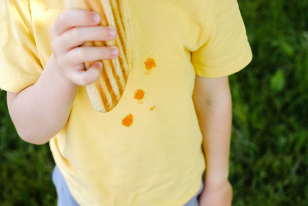 Taches de ketchup sur un t-shirt jaune. tache sale de la vie quotidienne pour le lavage et le concept propre. . Photo de haute qualité - Photo, image