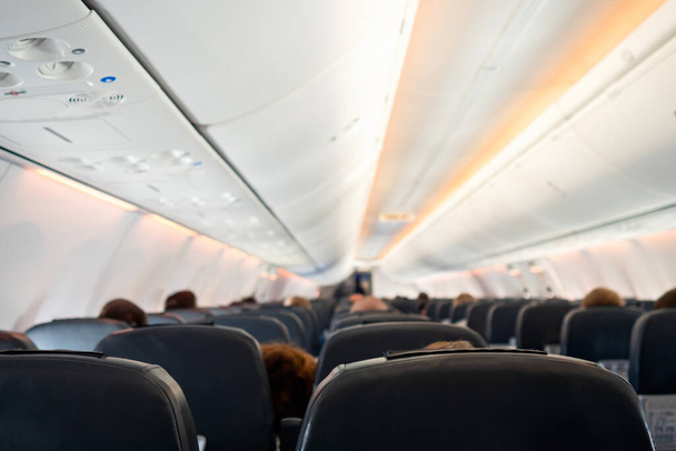 Επιβάτες μέσα στην καμπίνα των αεροσκαφών που κάθονται στις καρέκλες κατά τη διάρκεια της πτήσης - Φωτογραφία, εικόνα