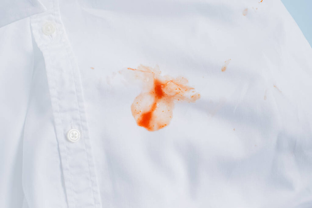 Chiuda la salsa di macchia rossa sporca su camicia bianca. vista dall'alto. Foto di alta qualità - Foto, immagini