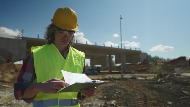 Stavební inženýr s dokumenty na staveništi silničního uzlu. - Záběry, video