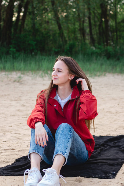 Retrato sincero de uma jovem caucasiana sentada na areia da praia - Foto, Imagem